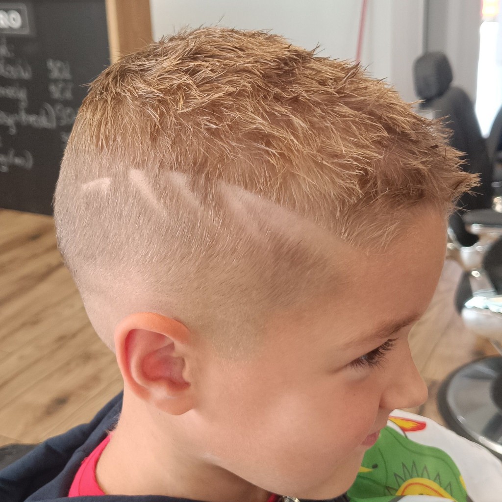 Krótka fryzura męska z mocnym fade i równą linią brody